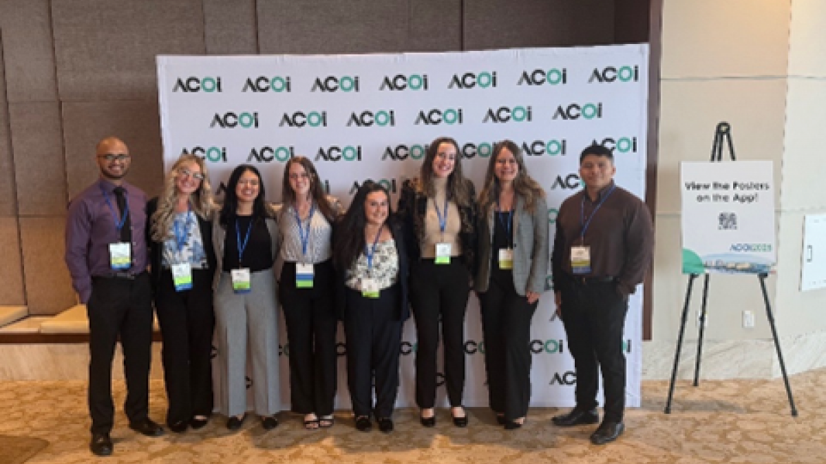 students at ACOI 2025 convention in front of step and repeat