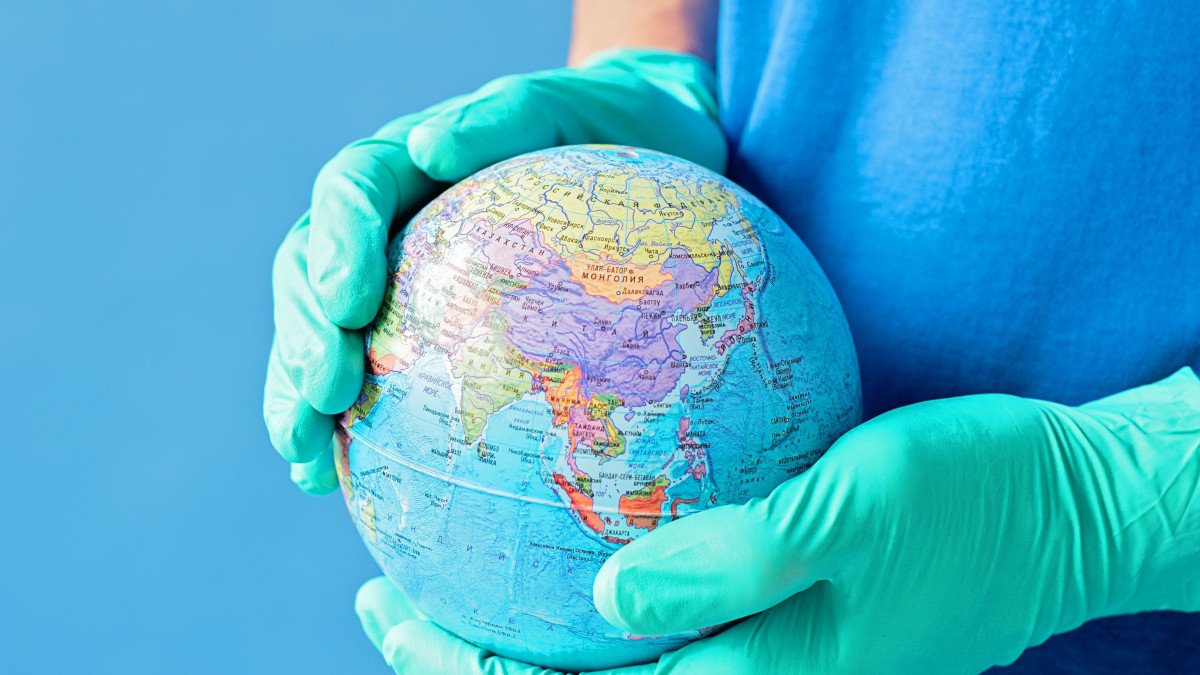 planetary health - gloved hands holding globe